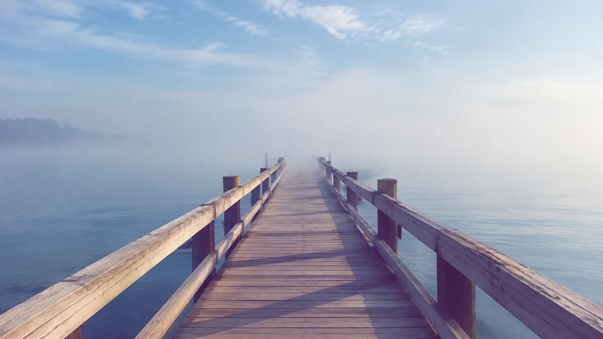 Pier fading into pale sea mist